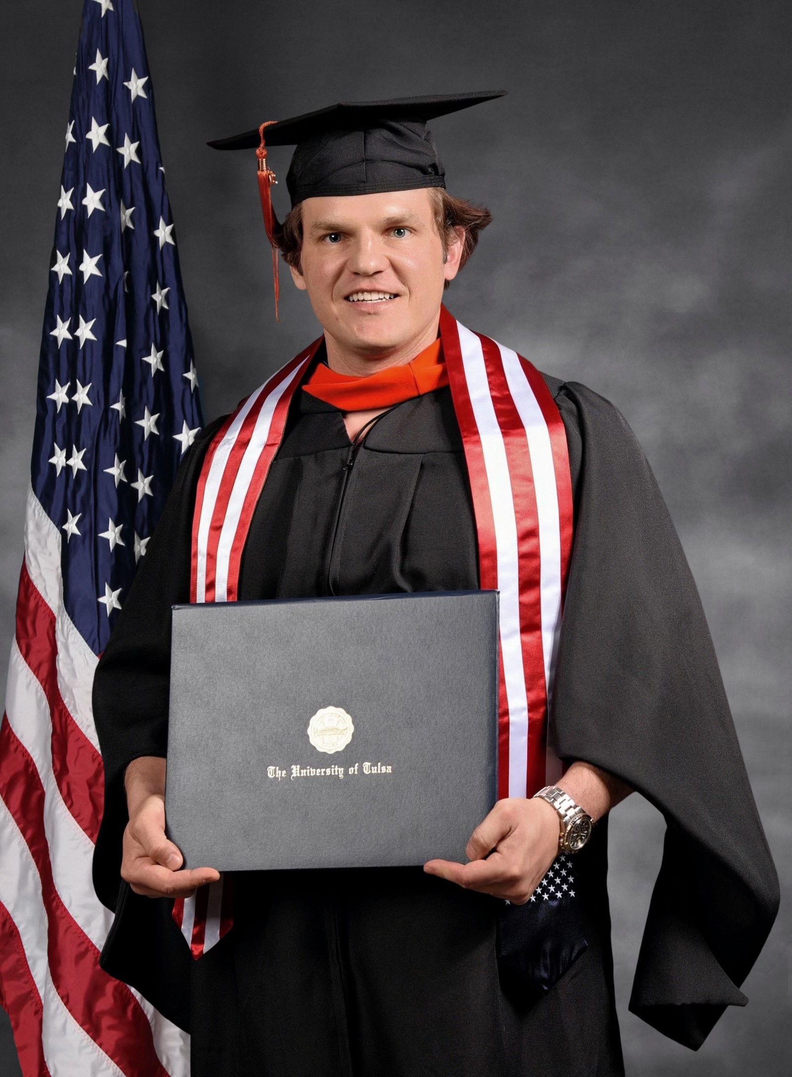 Ryan holding his University of Tulsa graduate degree